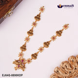 Two antique gold nakshi necklaces with pink stones and peacock pendants laid diagonally beside a wooden box