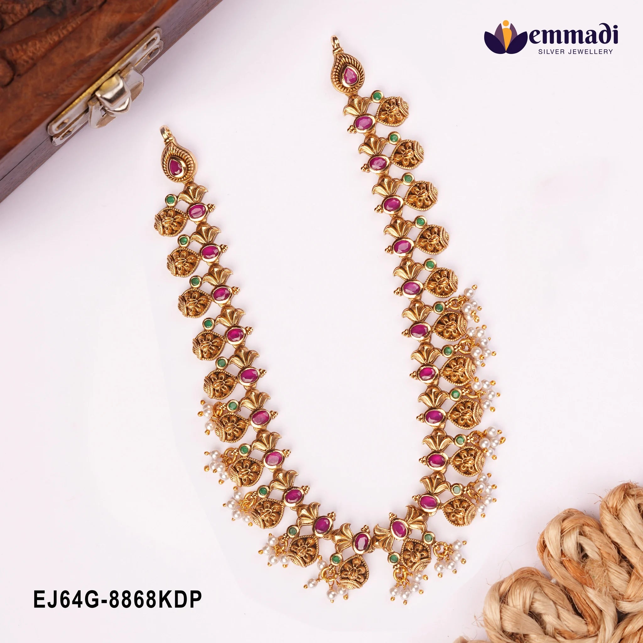 Antique gold-tone multicolour stone necklace with pearl drops displayed beside a wooden box clasp