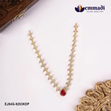 Red and white stone necklace laid on cream fabric beside a carved wooden box