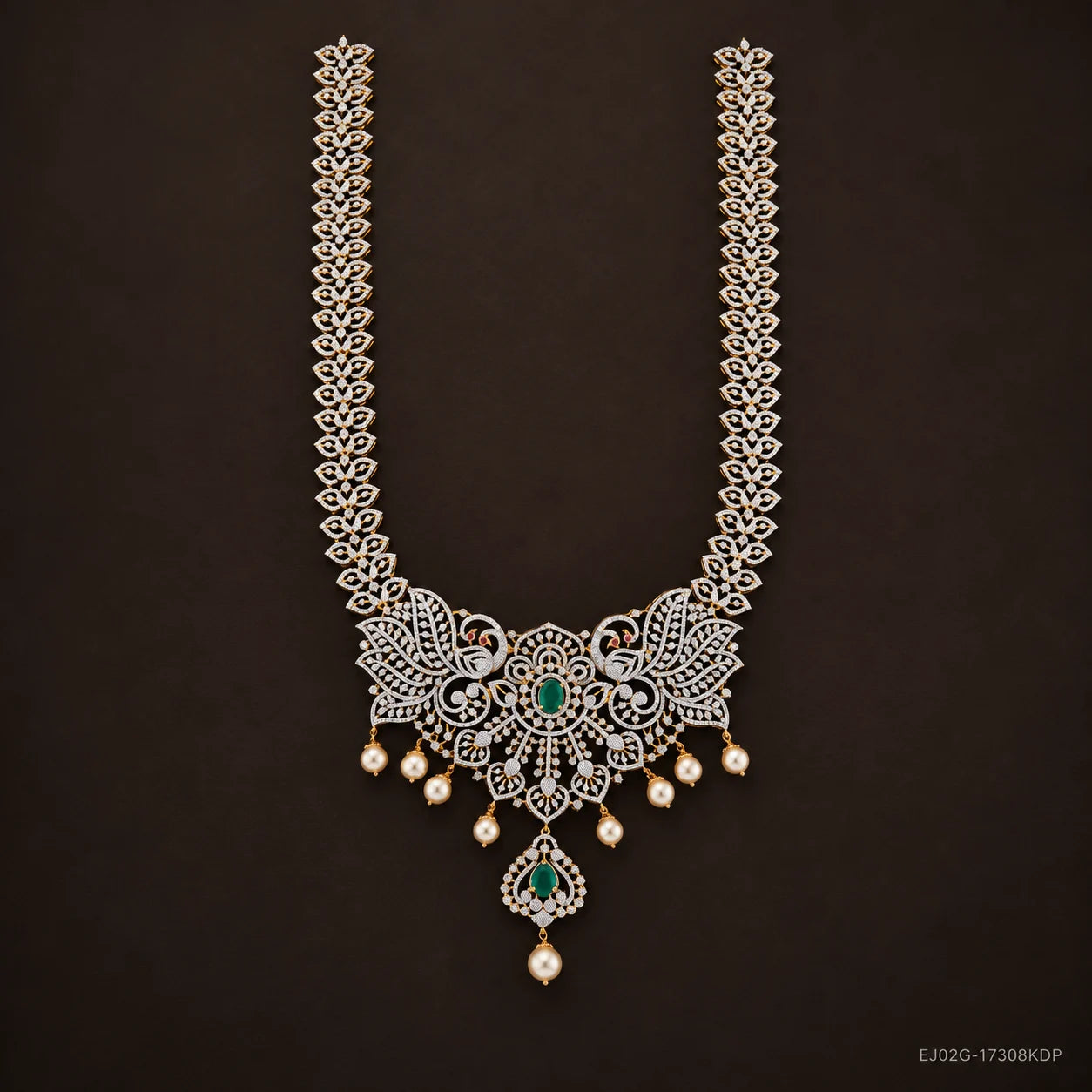 Long necklace with pave cz chain, peacock motifs and green stone pendant on dark brown background