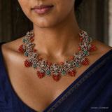 Close-up of the Victorian necklace on the neckline showing coral bead drops, green stones and pave scrollwork