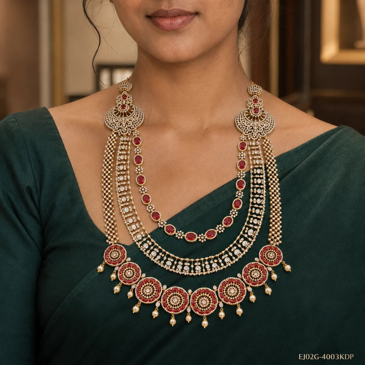 Close-up of red and white CZ long necklace with circular pendants and pearl drops on green blouse