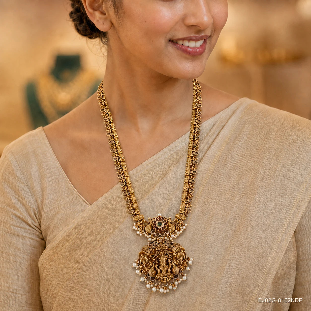 Close-up of the neckline showing the layered long necklace with ornate peacock and pendant design