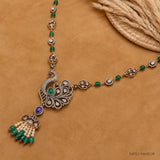 Flat lay of Victorian long necklace showing peacock pendant, green beads and tassel drop