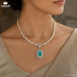 Detailed view of the neckline showing pearl beads, pave CZ links and the green stone pendant