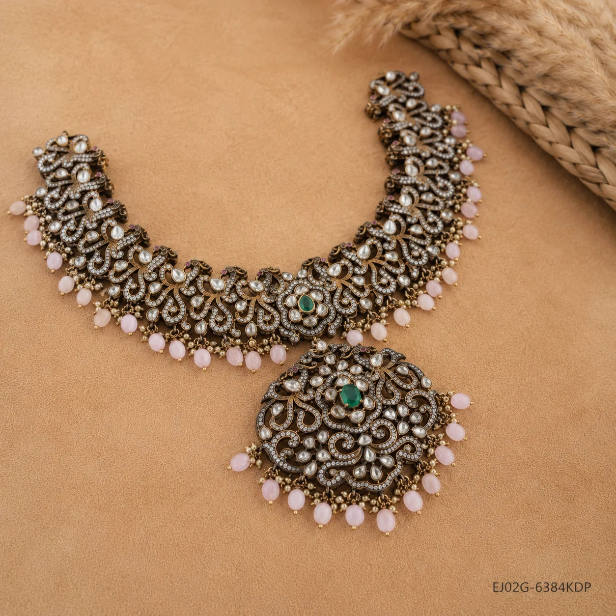 Victorian green necklace laid flat on beige fabric, showing intricate antique finish scrollwork and pendant