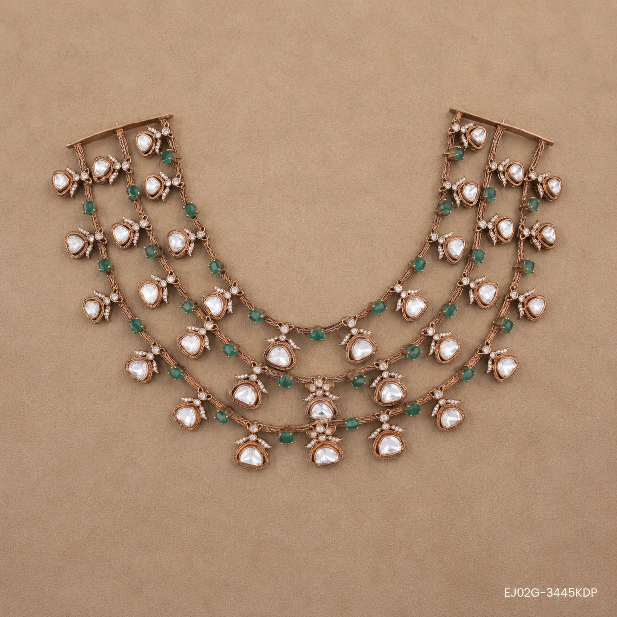 Flat lay of the three-tier Victorian necklace with white stone drops and green beads on a beige backdrop