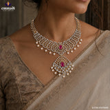 Close up of paisley design necklace on neckline showing pink stone pendant and pearl drop detailing
