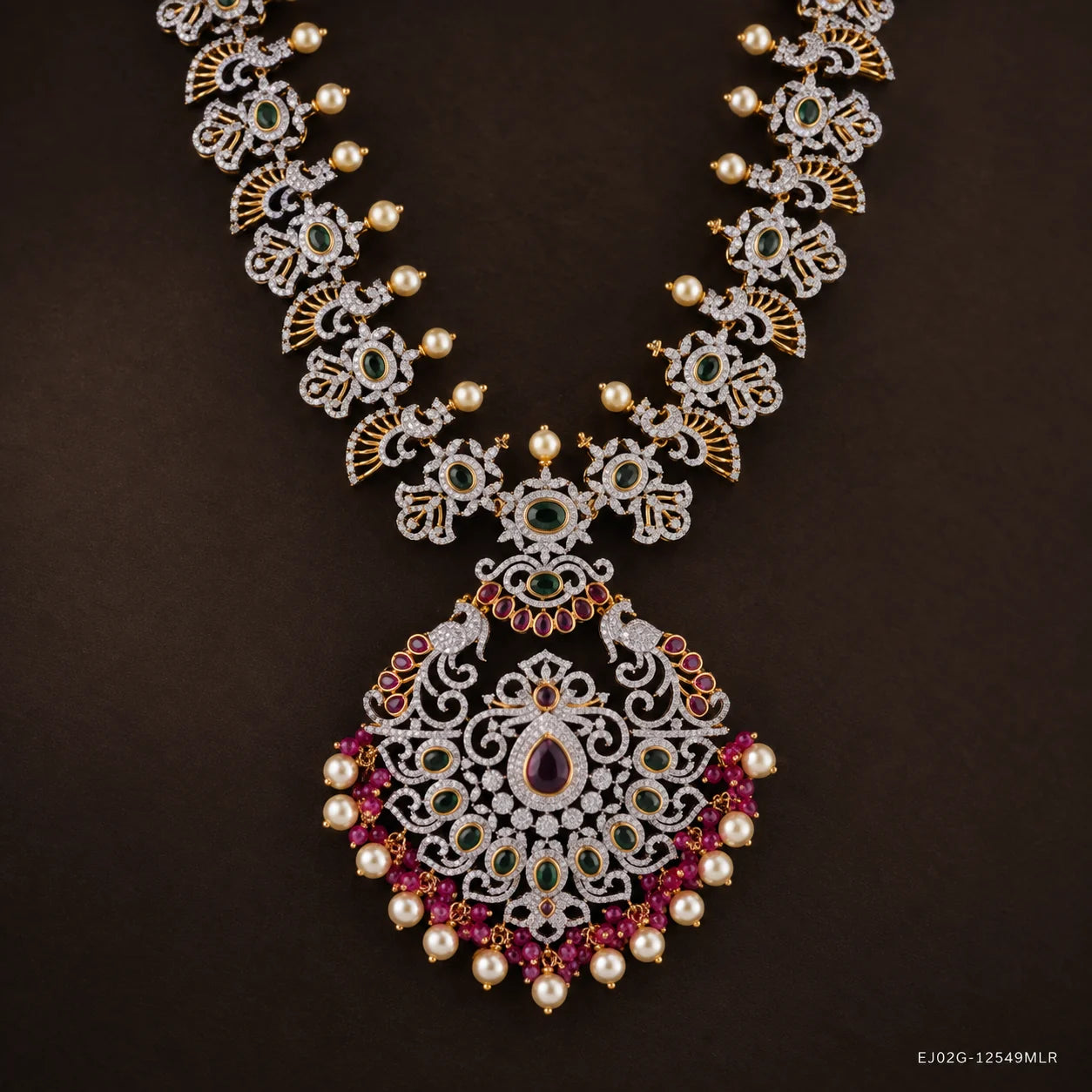 Close-up of the pendant showing peacock motifs, green stones and pink stone border with pearl drops