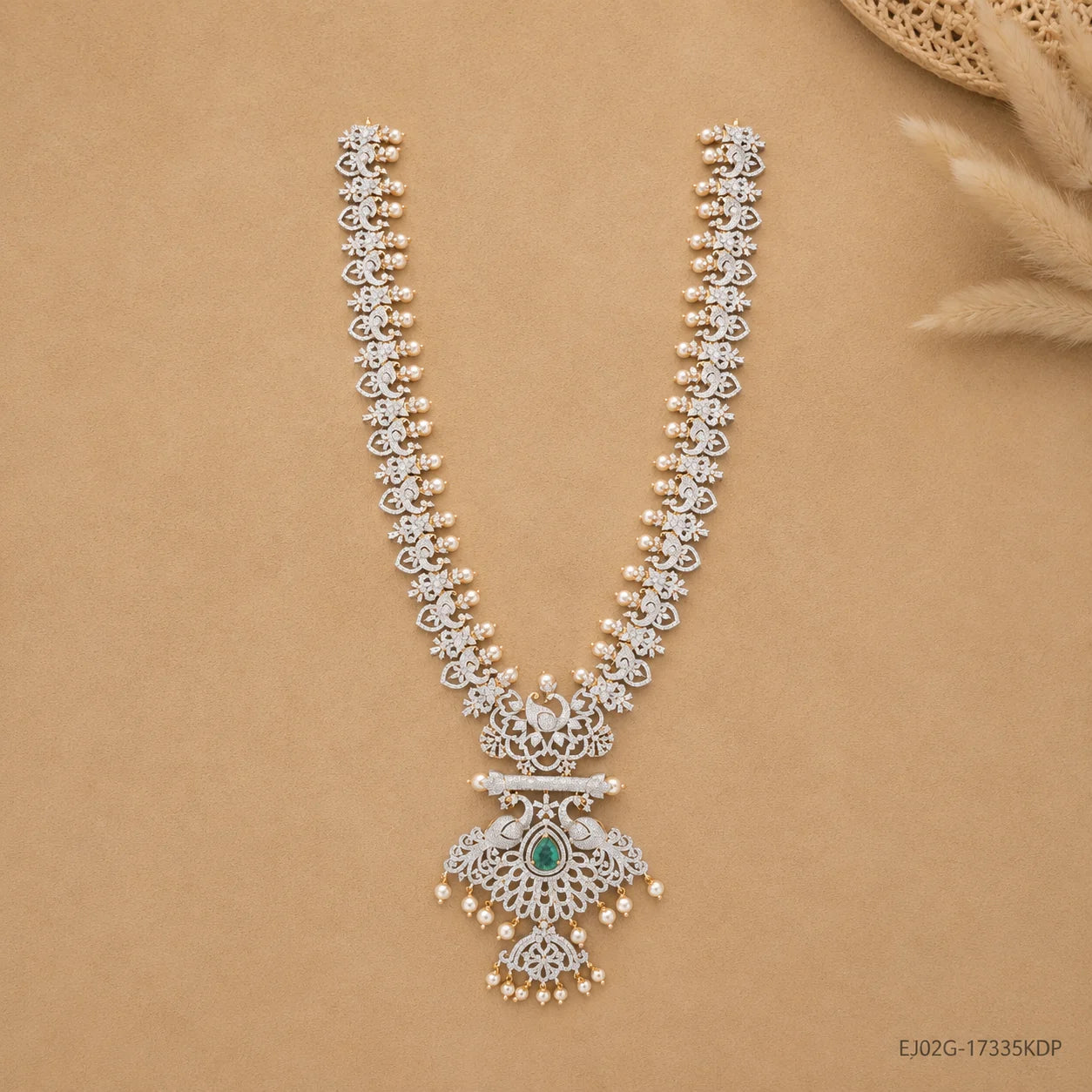 Long necklace laid flat in a V shape on beige fabric, showing full chain and pendant