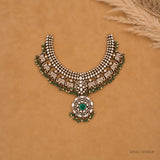 Flat lay of the full necklace on tan fabric showing symmetrical elephant and pendant design