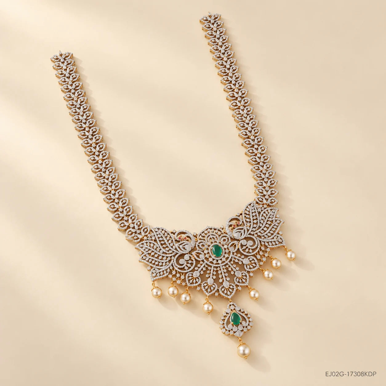 Long necklace arranged diagonally on cream fabric showing the full chain and pendant drop