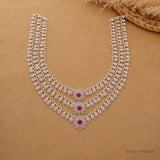 Full necklace laid flat on beige fabric showing both clasp ends and the complete three-tier floral design