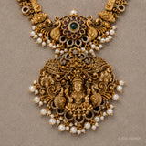 Close-up of the pendant showing the coloured stone cluster, deity figure, peacocks and pearl drops