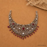 Flat lay close-up of necklace highlighting antique finish, cubic zirconia florals and red beads