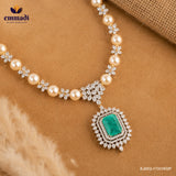 Necklace laid flat on fabric showing pearl beads, CZ floral clusters and the green stone pendant