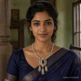 Woman in navy blue saree wearing the Ira Victorian green necklace with pearl tassels against a heritage backdrop