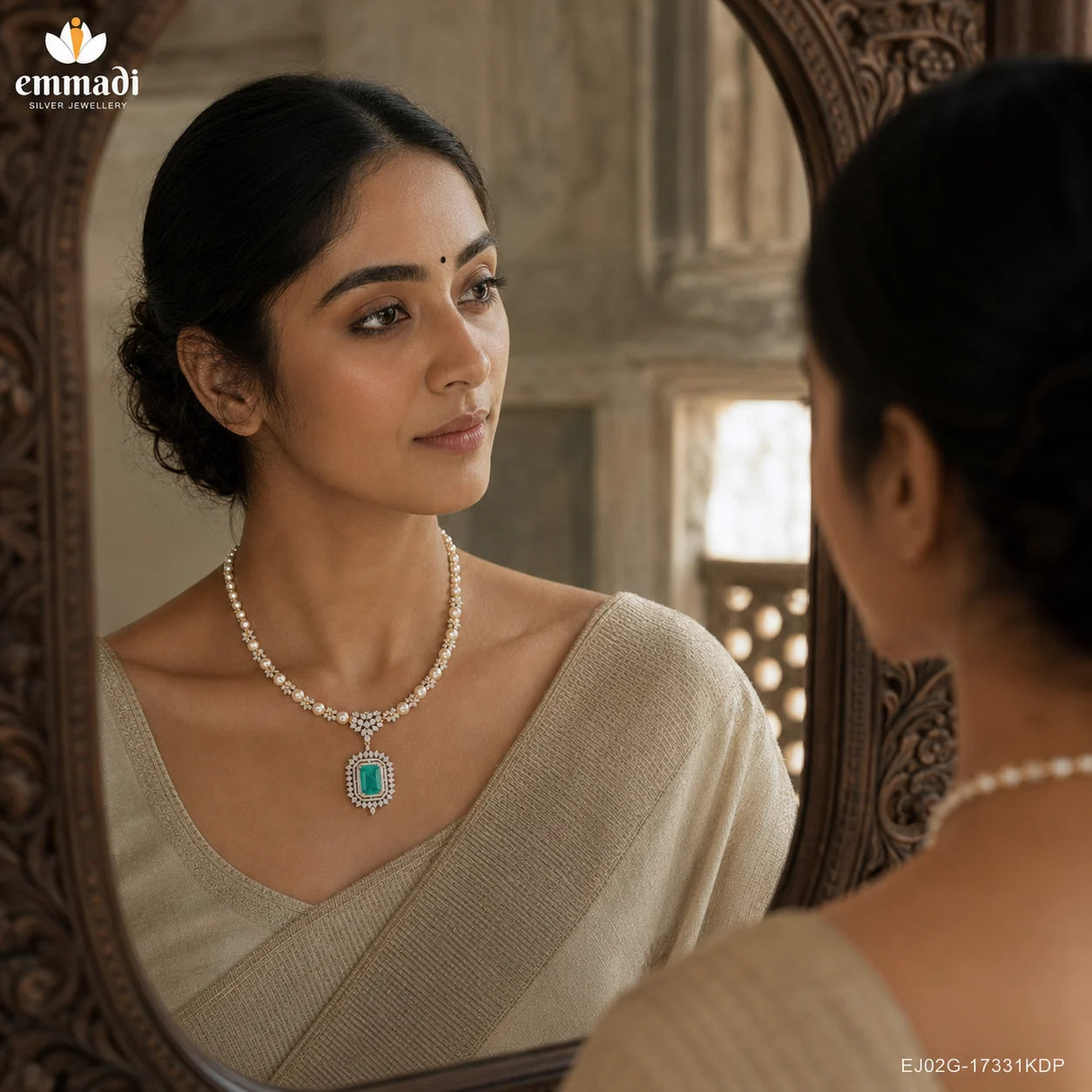 Woman in beige saree viewing herself in an ornate mirror, wearing a pearl and CZ necklace with green stone pendant