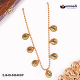 Two matching gold-tone beaded necklaces with green stone teardrop pendants laid against a wooden box backdrop