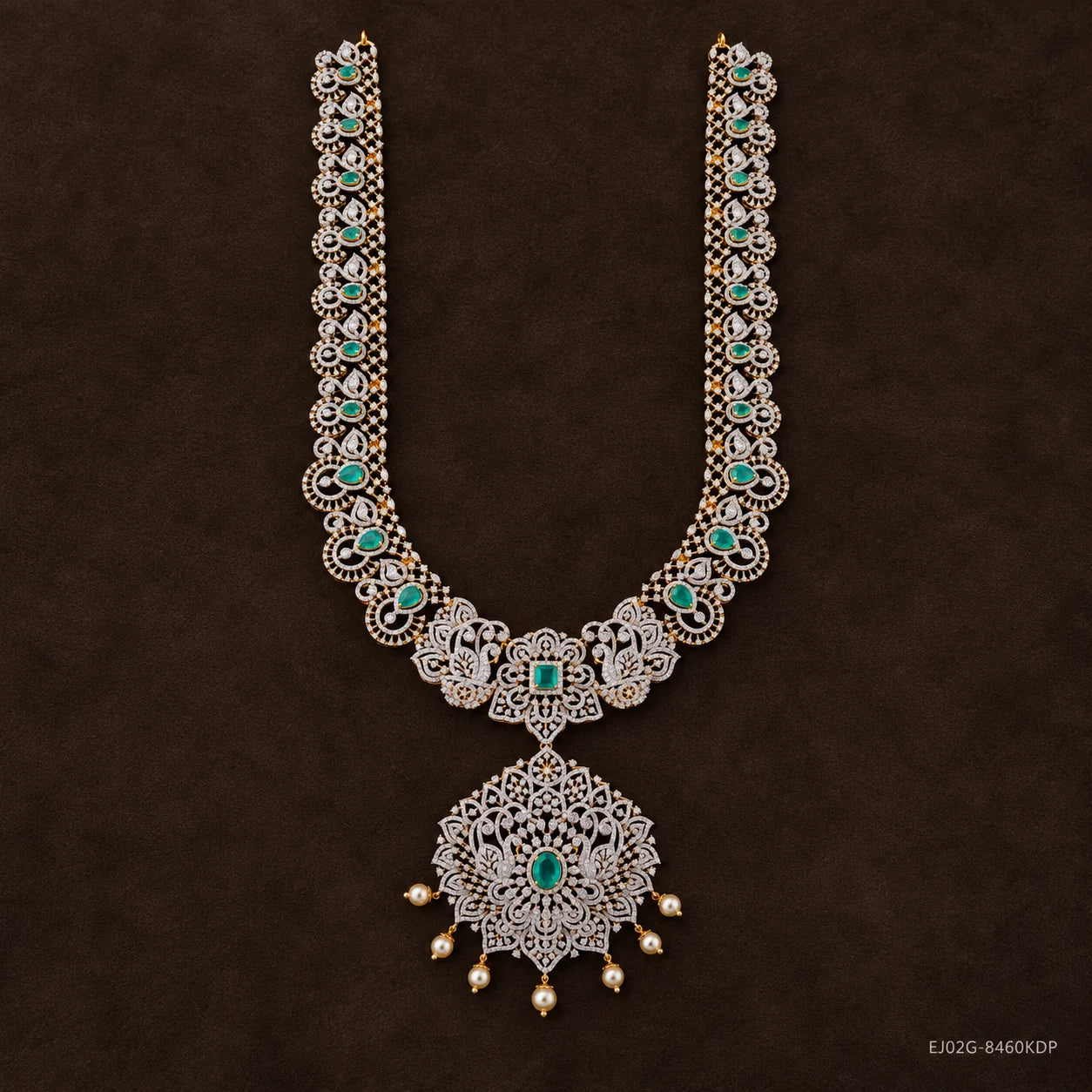 Green stone long necklace with peacock motifs and pearl drop pendant on dark brown background