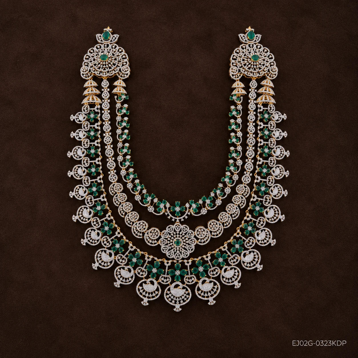 Three-tier green and white pave long necklace with swan pendants, shown on a dark brown background