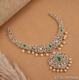 Premium CZ necklace with green stones and pearl drops laid on a beige background with matching pendant