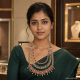 Woman in green saree wearing a red and white layered CZ long necklace with pearl drops