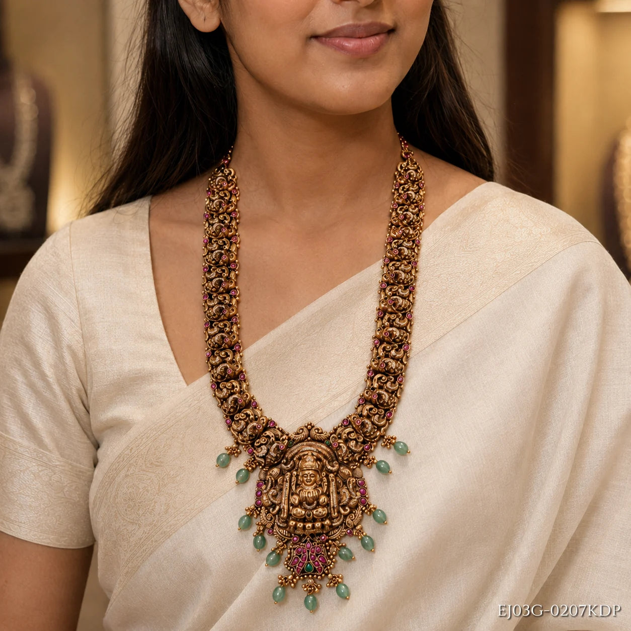 Close-up of the necklace on the model showing layered Nakshi strands, pink stones and green teardrop beads