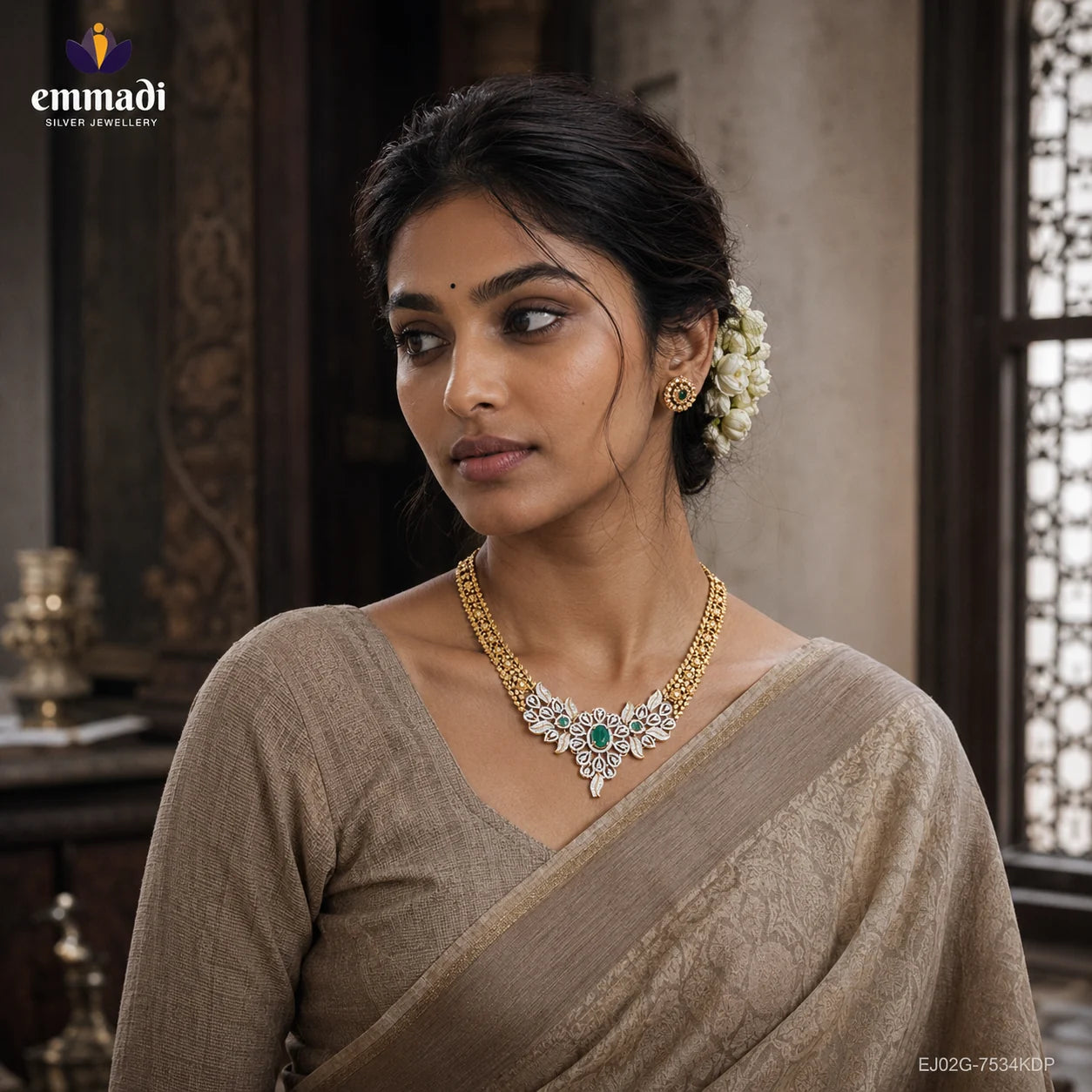 Close-up of woman in beige saree wearing a layered gold-tone necklace with CZ pave and green stone centrepiece