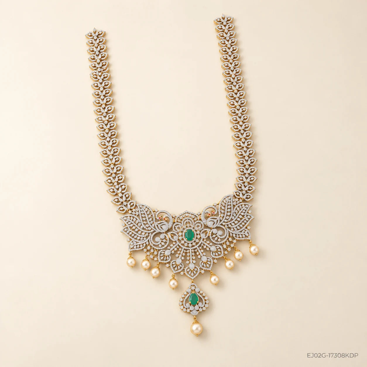 Full view of the green stone long necklace with pearl drops laid on a cream background