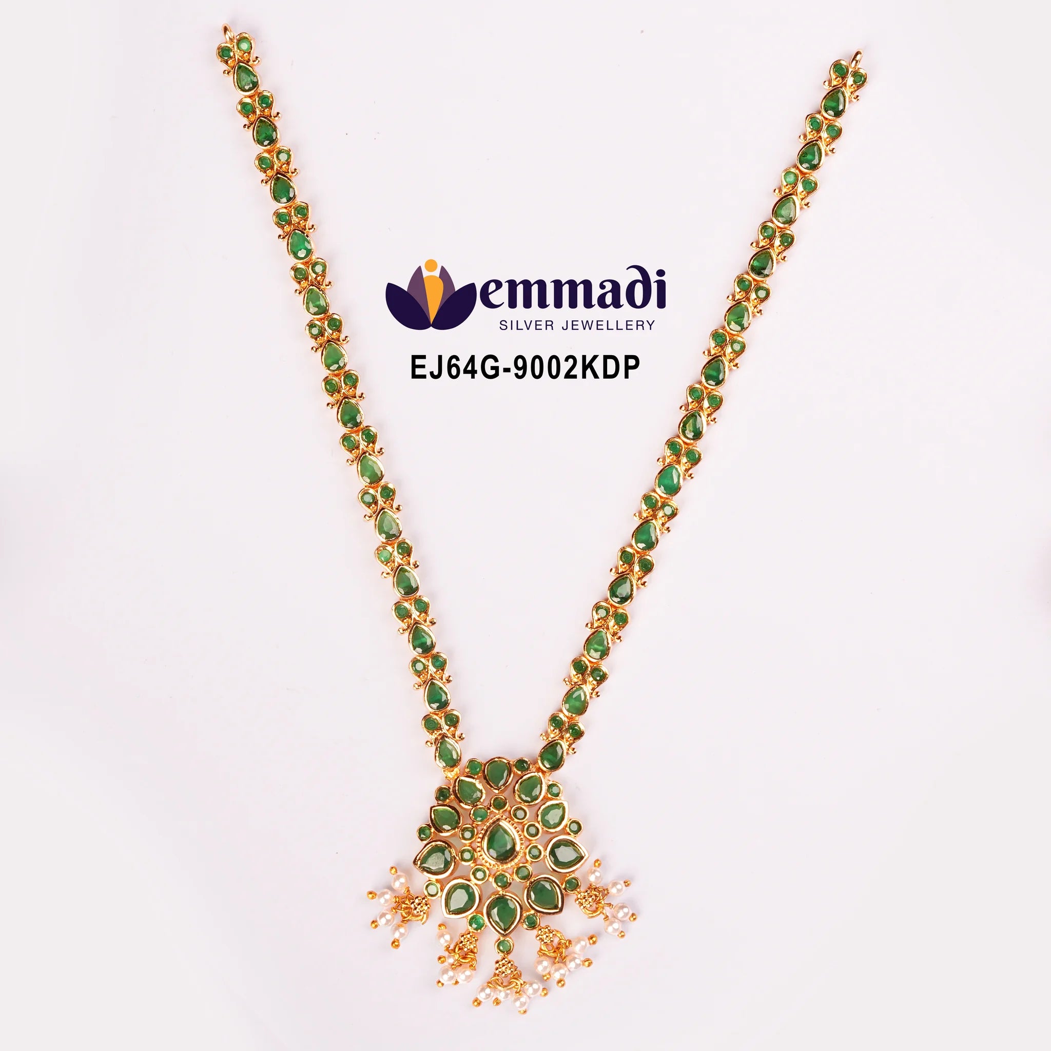 Green stone necklace with floral pendant and pearl tassels laid flat on white background