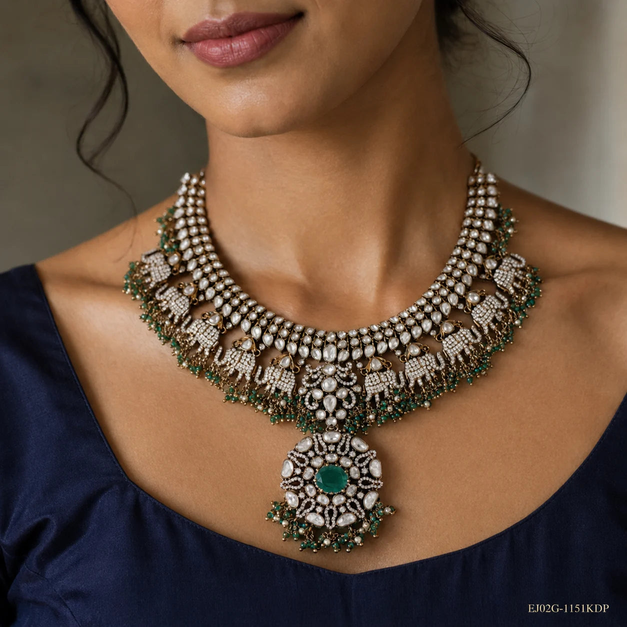 Close-up of the necklace on the neck showing elephant motifs and central green stone pendant