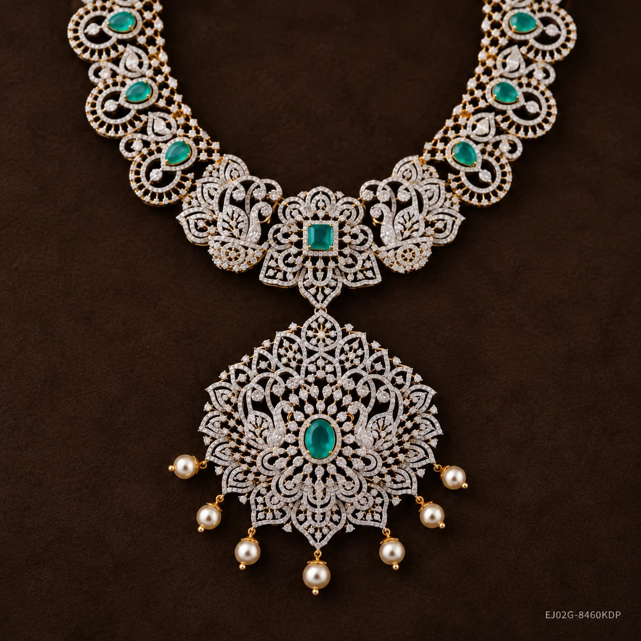 Close-up of floral pendant with peacock motifs, green stone centre and pearl drops