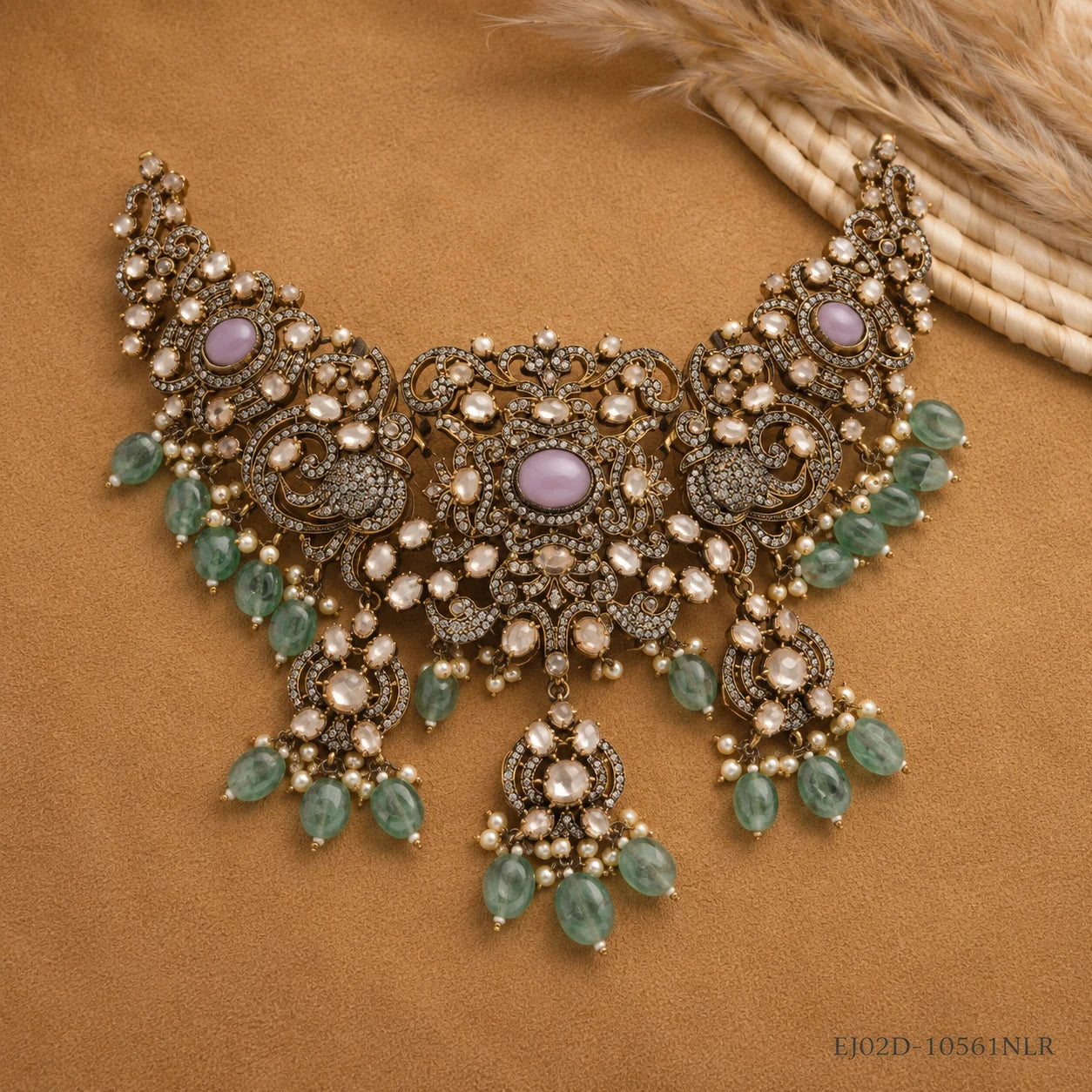 Flat lay of the Victorian choker necklace with lavender cabochons and green stone drops on tan fabric