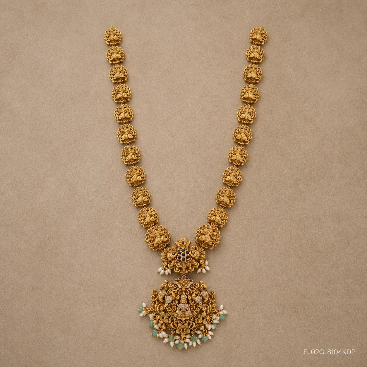 Flat lay of the full long necklace showing repeating carved floral links and the ornate pendant