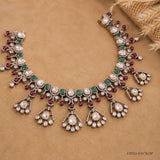 Antique finish Victorian necklace laid flat, showing full row of green stones and clear stone drops