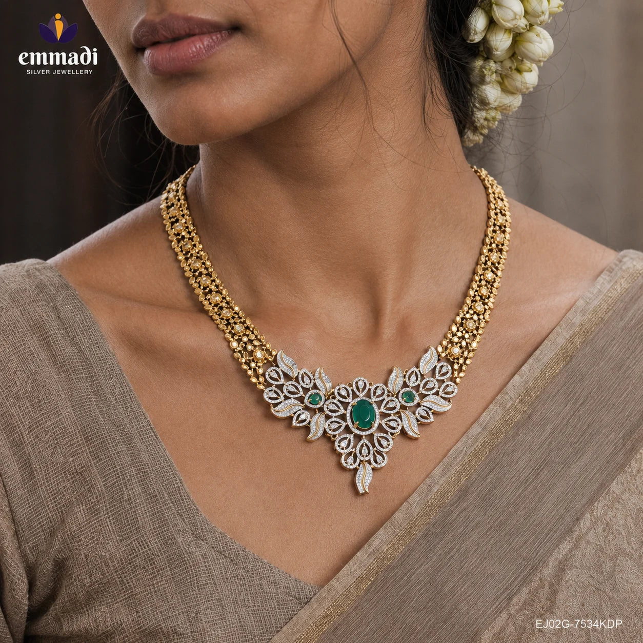 Close-up of neckline showing a gold-tone necklace with CZ floral and leaf motifs and three green stones