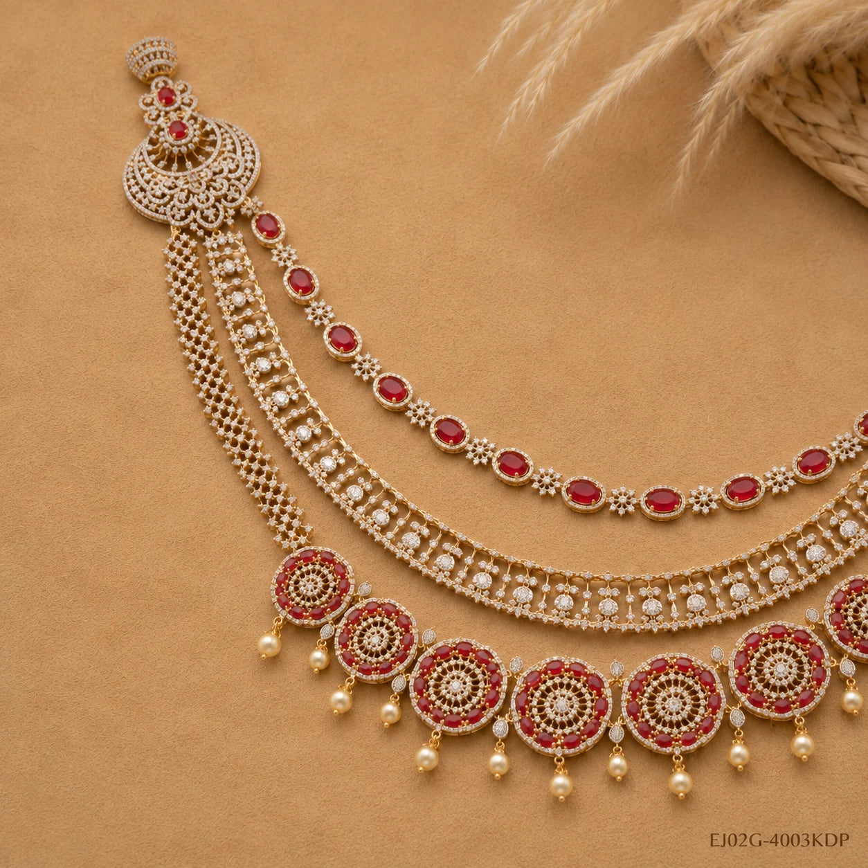 Flat lay close-up of red CZ long necklace showing floral pendant, chain layers and pearl details