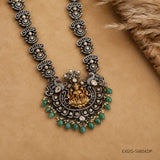 Close up of the pendant showing peacock motifs, goddess figure and pearl and green beading