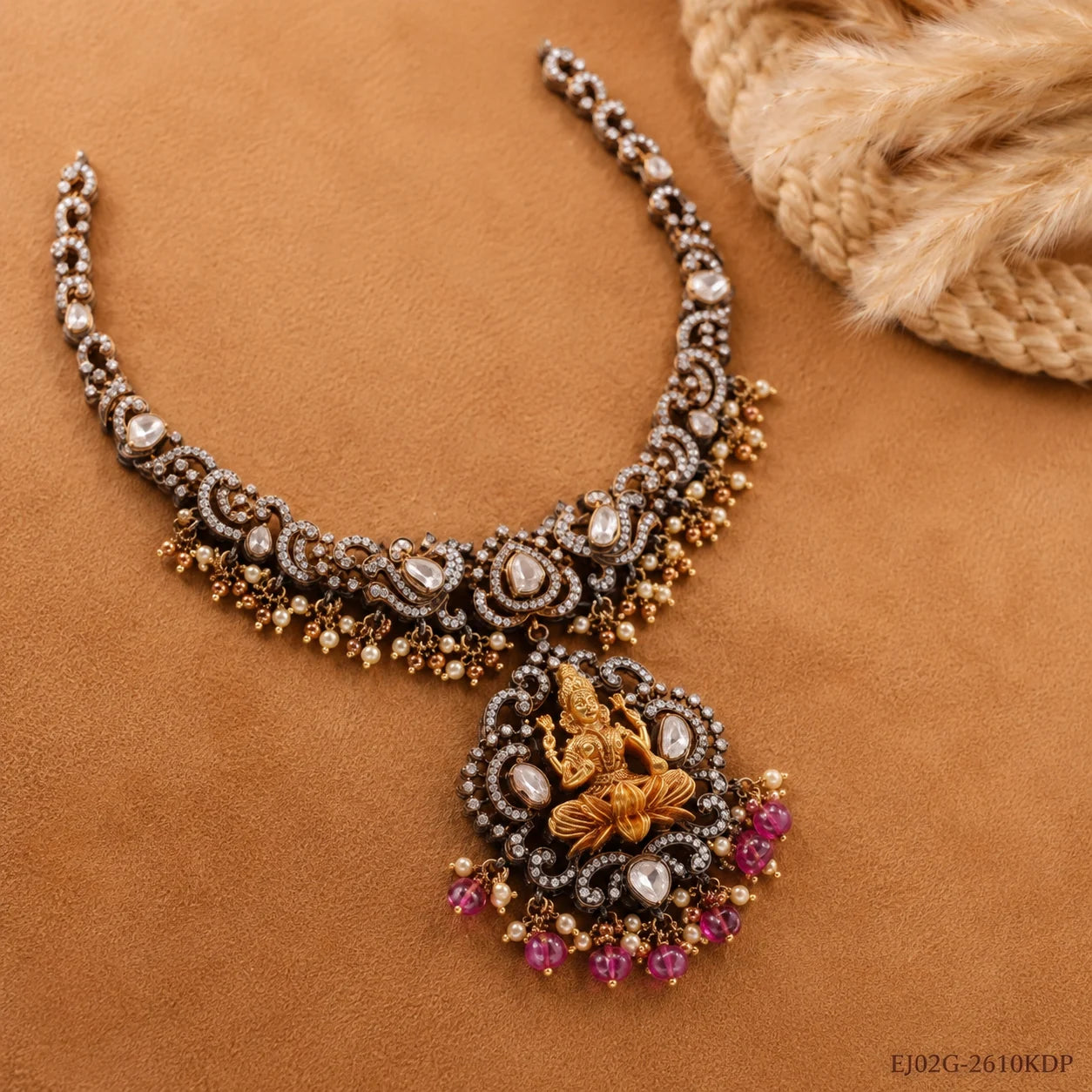Necklace laid flat on tan fabric showing paisley design and gold-tone seated deity pendant