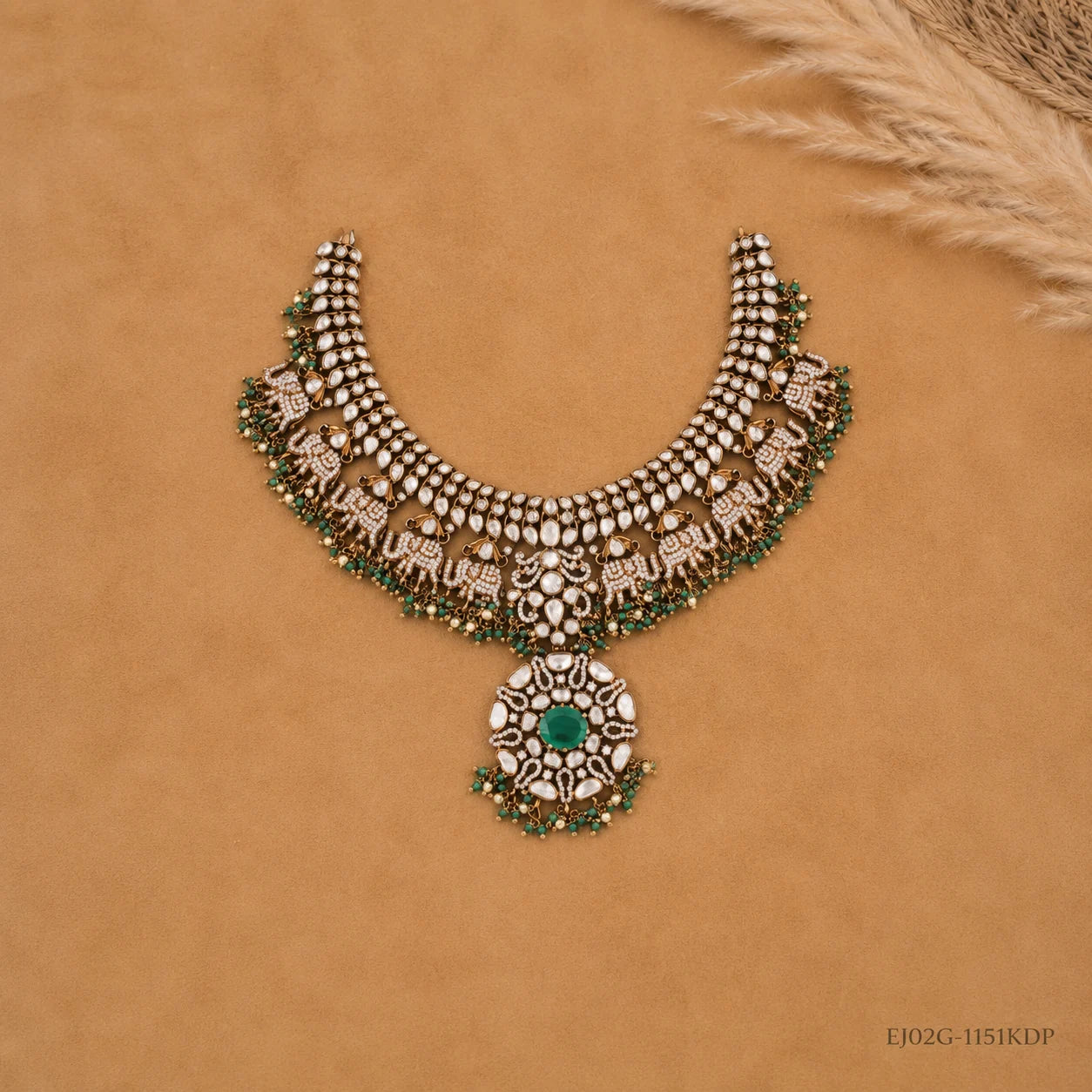 Flat lay of the full necklace on tan fabric showing symmetrical elephant and pendant design