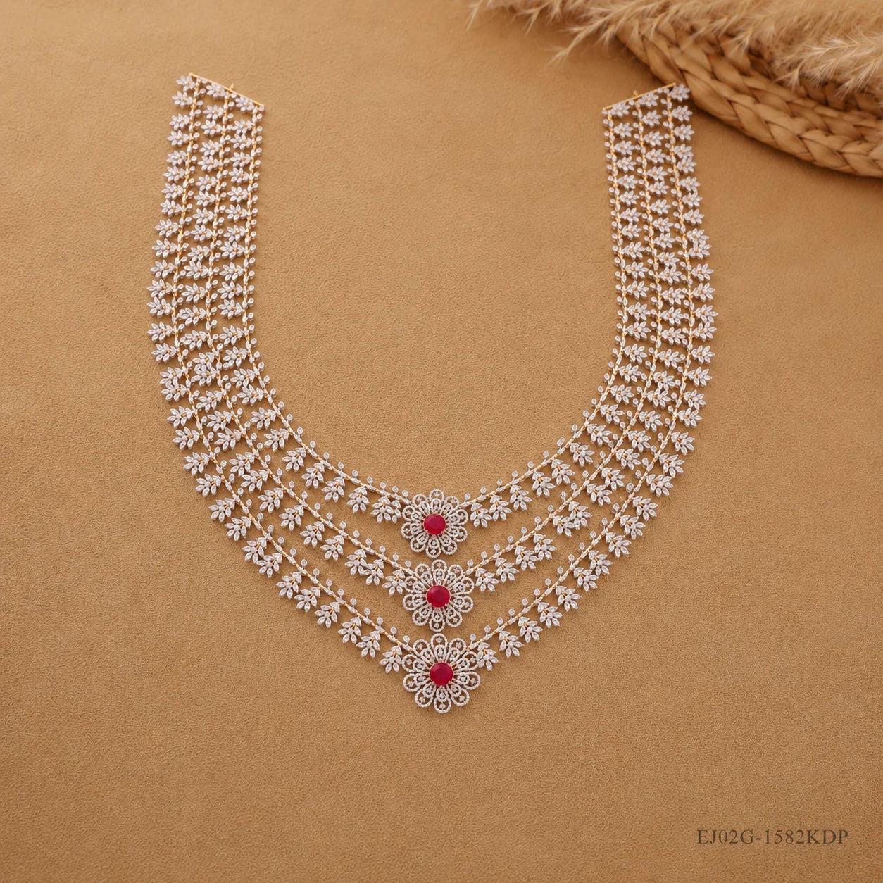 Full necklace laid flat on beige fabric showing both clasp ends and the complete three-tier floral design