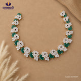 Flat lay of the green and white floral cubic zirconia necklace displayed open on beige fabric