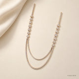 Ira Ethika white long necklace styled flat on cream fabric with draped silk corner
