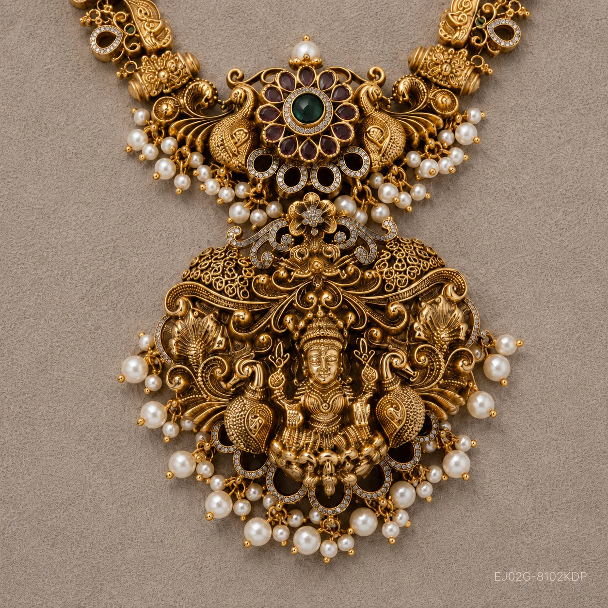Close-up of the pendant showing the coloured stone cluster, deity figure, peacocks and pearl drops