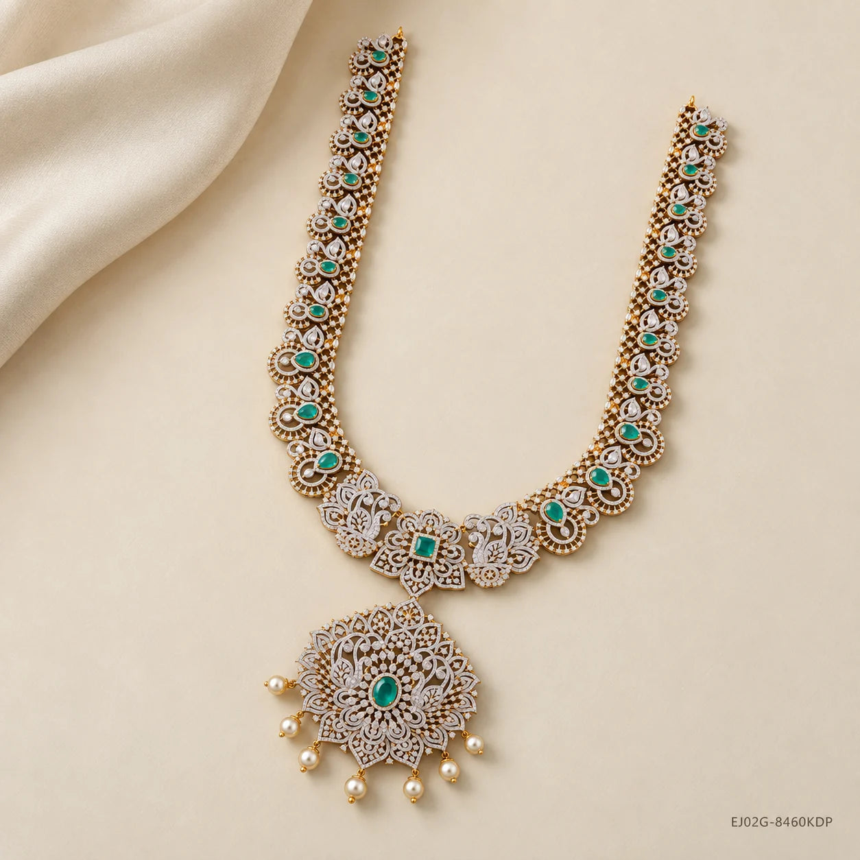 Full view of green stone long necklace with scalloped border laid on cream fabric