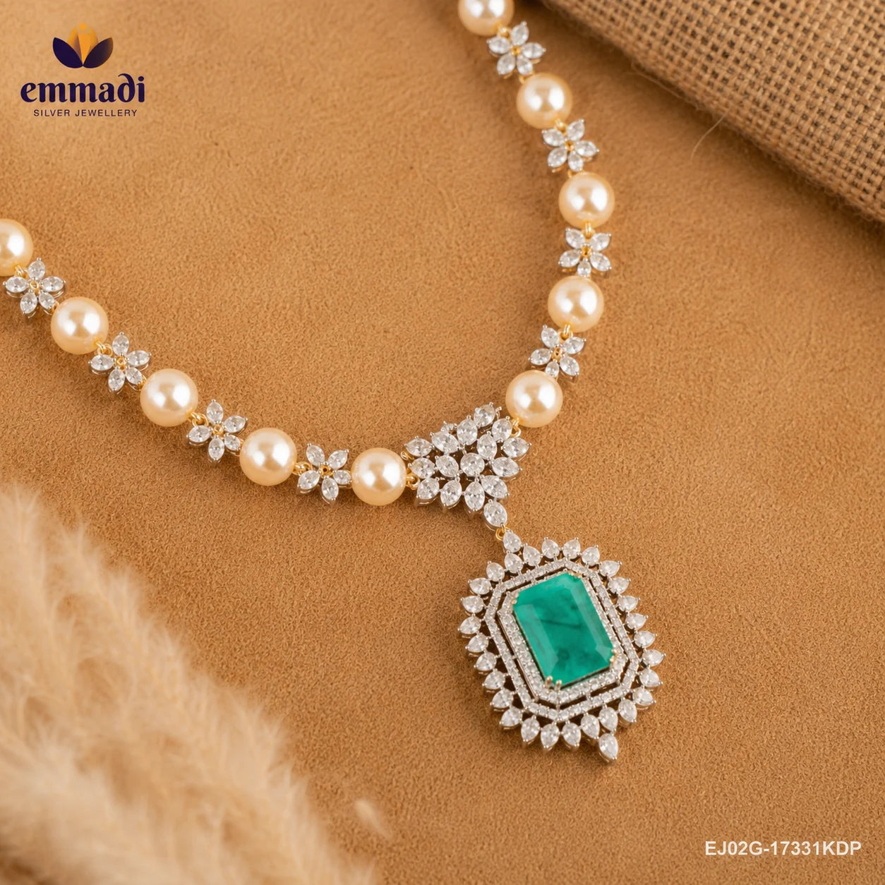 Necklace laid flat on fabric showing pearl beads, CZ floral clusters and the green stone pendant