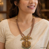 Close-up of the necklace worn on the neck showing the double strand of pink stones and pendant detail