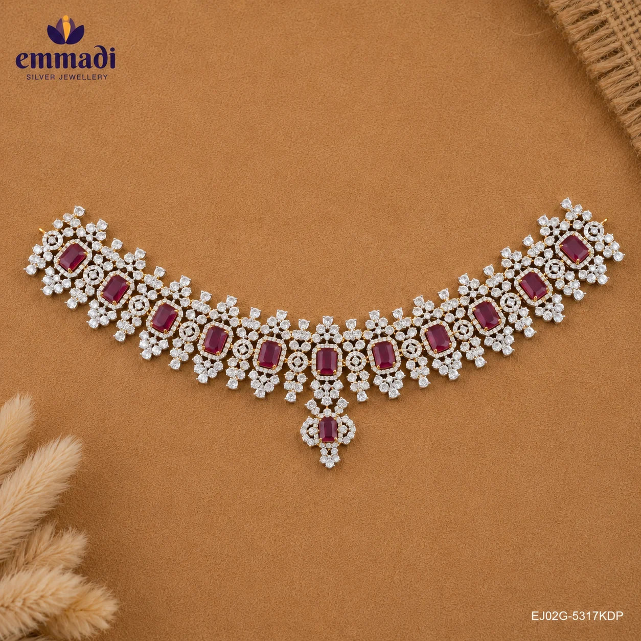 Flat lay of a pink and white CZ choker with pendant drop placed on a tan background beside dried flowers