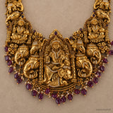 Close-up flat-lay of the central pendant with seated deity, elephants and pink bead drops